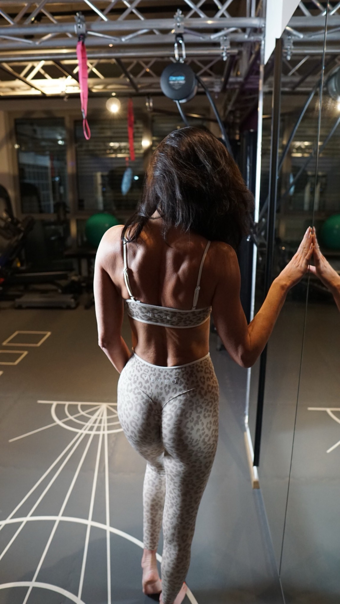 Ella von hinten am Spiegel im Trainingsstudio